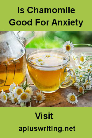 A cup of tea beside a teapot and chamomile flowers.