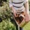 Woman sprinkling coffee grounds around plants in the garden