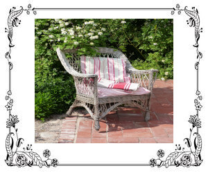 A wicker chair on a patio with a plant behind it.