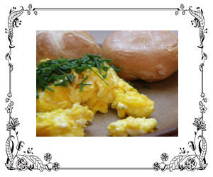 A plate of scrambled eggs garnished with chives.