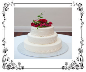 A white cake with red flower topper