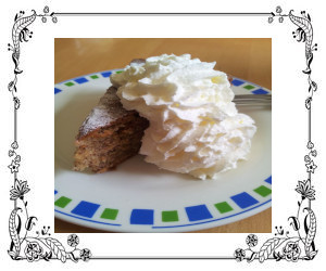 A large dollop of ribboned whipped cream on a slice of cake.