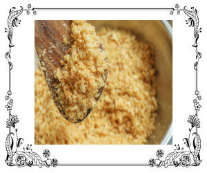 A spoonful of graham cracker crust crumble on a wooden spoon