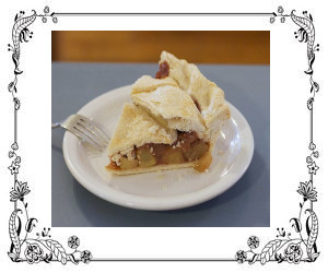 A slice of apple pie on a white plate with fork