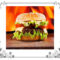 A hamburger in a bun with flames behind it