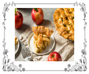 A slice of apple pie on a dish next to the full dish pie and 3 fresh apples.