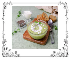 A bowl of lettuce soup with bread and garnishes.