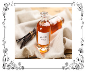 A bottle of vanilla extract beside vanilla beans lying on a towel.