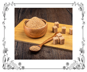 Brown sugar in a bowl, spoon, and sugar cubes on a serving board.