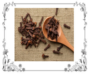 Whole cloves on a spoon and table